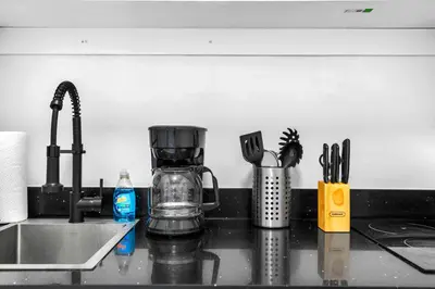 a kitchen counter with a coffee maker and utensils at Comfy Studio W Beautiful Space! in Miami