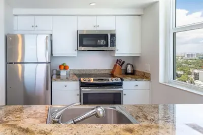 a kitchen with white cabinets and a stainless steel refrigerator at MVR Unforgettable Balconies Await You in Miami