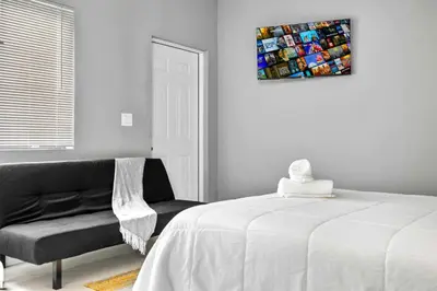 a bedroom with a bed and a chair and a painting at Studio in Miami - Ideal for Couples & Travelers in Miami