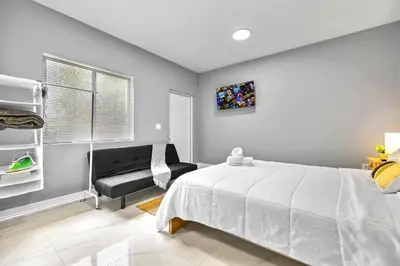 a bedroom with a white bed and a chair at Studio in Miami - Ideal for Couples & Travelers in Miami