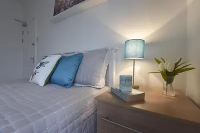a bedroom with a bed with a night stand and a lamp at Gorgeous apartment near South Beach in Miami Beach
