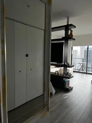 a living room with a white cabinet and a tv at Luxury Studio in Miami