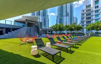 a row of chairs and tables on a field of grass at Luxury Studio in Miami