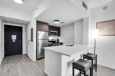a kitchen with a counter and two stools and a refrigerator at Best Location 2 bedrooms 2 bathrooms in Miami