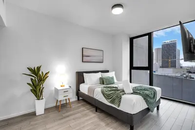 a white bedroom with a bed and a large window at Best Location 2 bedrooms 2 bathrooms in Miami