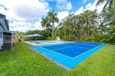 a tennis court in the yard of a house at 4BR Biscayne River Home- Pool & Pickleball Fun home in Miami