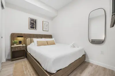a bedroom with a large bed and a mirror at Luxury Miami Beach Condo At 72 Park in Miami Beach