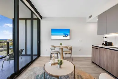 a kitchen and living room with a table and chairs at Luxury Miami Beach Condo At 72 Park in Miami Beach