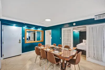 a dining room with blue walls and a table and chairs at Cozy 2BR Condo with Resort Perks Pools Gym Sauna in an Oceanfront Building 409 in Miami Beach