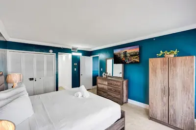 a bedroom with a large bed and blue walls at Cozy 2BR Condo with Resort Perks Pools Gym Sauna in an Oceanfront Building 409 in Miami Beach