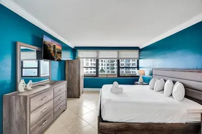 a bedroom with blue walls and a large bed at Cozy 2BR Condo with Resort Perks Pools Gym Sauna in an Oceanfront Building 409 in Miami Beach