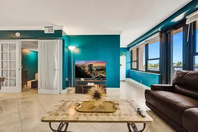 a living room with blue walls and a couch at Cozy 2BR Condo with Resort Perks Pools Gym Sauna in an Oceanfront Building 409 in Miami Beach
