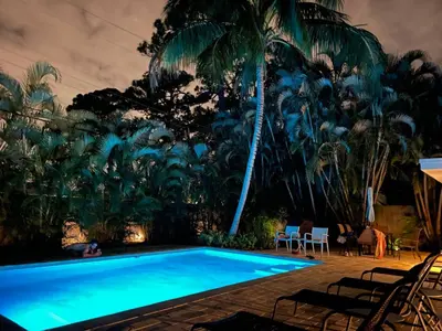 a swimming pool with chairs and palm trees at Chic Fort Lauderdale Getaway w/Private Heated Pool in Fort Lauderdale