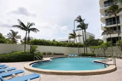 a swimming pool with lounge chairs and a building at Beachfront 2 BR Apt Full Kitchen - No Resort Fee in Hollywood