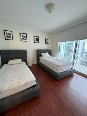 a bedroom with two beds and a large window at Bright 2BR Apartment in Prime Brickell Location in Miami