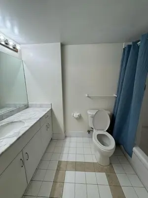 a bathroom with a toilet and a sink and a mirror at Bright 2BR Apartment in Prime Brickell Location in Miami