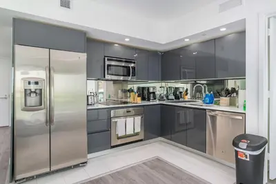 a kitchen with black cabinets and a stainless steel refrigerator at Spacious and bright in the heart of Brickell in Miami