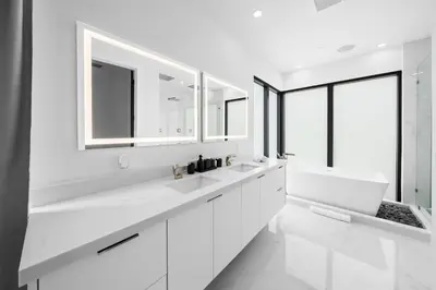 a white bathroom with two sinks and mirrors at Modern Zen Oasis in Design District Sleeps 16 in Miami