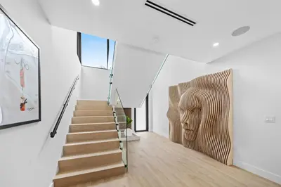 a staircase in a white house with a stair case at Modern Zen Oasis in Design District Sleeps 16 in Miami