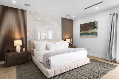 a bedroom with a large white bed and a rug at Modern Zen Oasis in Design District Sleeps 16 in Miami