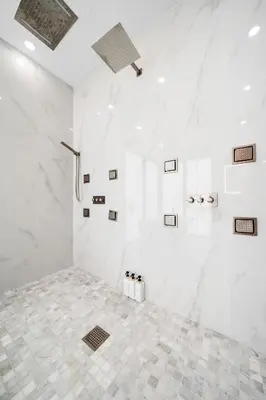 a white bathroom with a shower and a tiled floor at Modern Zen Oasis in Design District Sleeps 16 in Miami