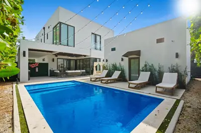 a villa with a swimming pool in front of a house at Modern Zen Oasis in Design District Sleeps 16 in Miami