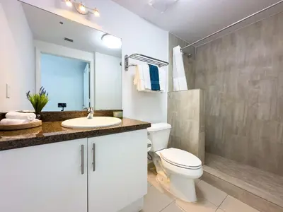 a white bathroom with a toilet and a sink at Miami top stay is nearly sold in Miami