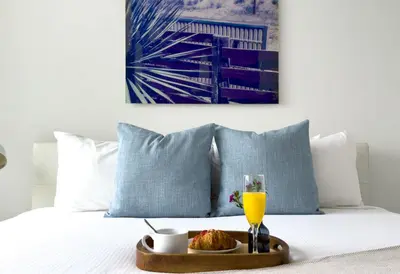 a tray of food and a glass of orange juice on a bed at Miami top stay is nearly sold in Miami