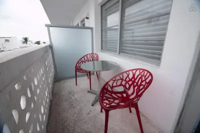 two red chairs and a table on a balcony at Ocean Drive Studio Roof top Pool and Bar in Miami Beach
