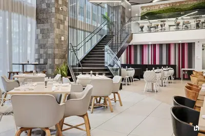 a restaurant with tables and chairs and a staircase at Downtown Vibes Pool Gym & Oceanview in Miami