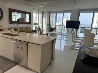 a kitchen and living room with a view of a building at Family Oriented Apartments with unbelievable views in Hallandale Beach