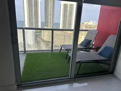a balcony with two chairs and a view of the city at Family Oriented Apartments with unbelievable views in Hallandale Beach