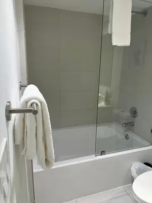 a bathroom with a shower and a bath tub with towels at Family Oriented Apartments with unbelievable views in Hallandale Beach
