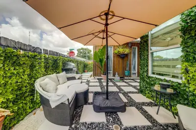 a patio with a couch and an umbrella at Mod Bungalow with Ultra-Private Outdoor Hang Space! in Miami Gardens