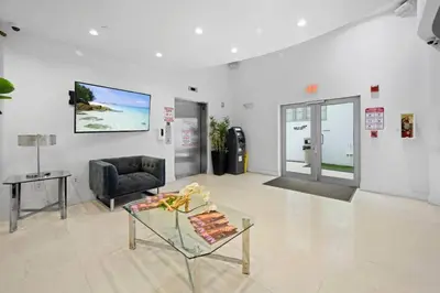 a living room with a chair and a glass table at Heart of South Beach Balcony Rooftop Pool in Miami Beach