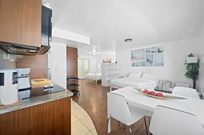 a kitchen and living room with a table and chairs at Cozy Ocean Drive Studio - Roof top Pool and Bar in Miami Beach