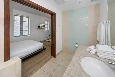 a bathroom with a bed and a sink and a mirror at Steps from the Ocean Comfy Studio with King Bed in Miami Beach