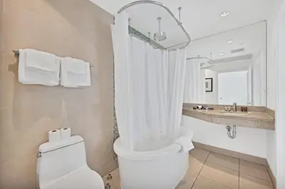 a white bathroom with a toilet and a sink at Stylish Studio in South Beach with Ocean Views in Miami Beach