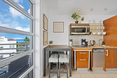 a kitchen with a table and a microwave at Stylish Studio in South Beach with Ocean Views in Miami Beach