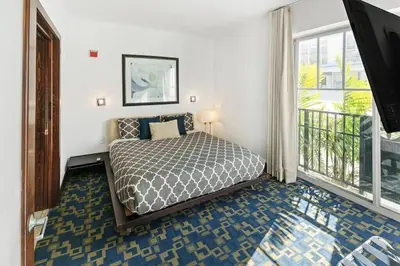 a bedroom with a bed and a large window at Heart of the Ocean Drive 1BDR Rooftop Pool with cabanas in Miami Beach