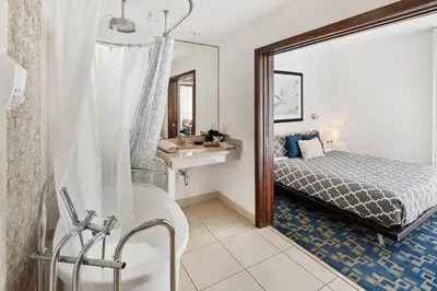 a bathroom with a tub and a bed and a sink at Heart of the Ocean Drive 1BDR Rooftop Pool with cabanas in Miami Beach