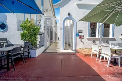 a patio with tables and chairs and an umbrella at Ocean Drive 1BDR Rooftop Pool with cabanas in Miami Beach