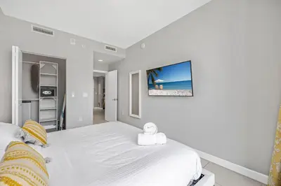 a bedroom with a bed with a tv on the wall at Modern Doral Condo w Free Parking in Miami