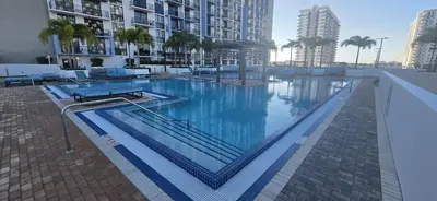 a large swimming pool with blue water in a building at Modern Doral Condo w Free Parking in Miami