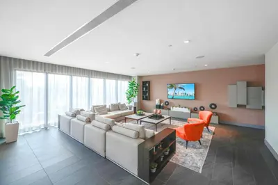 a living room with a large couch and orange chairs at Modern Doral Condo w Free Parking in Miami