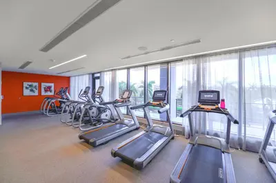 a gym with a row of treadmills and exercise bikes at Modern Doral Condo w Free Parking in Miami