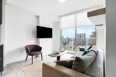 a living room with a couch and a chair and a large window at Luxury Condo w Rooftop Pool & Gym in Miami