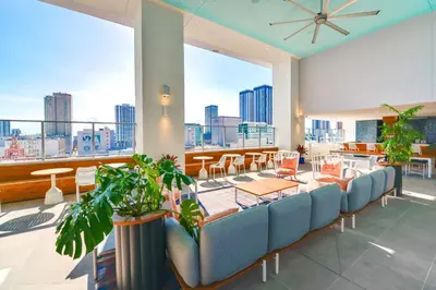 a room with chairs and tables and a large window at Luxury Condo w Rooftop Pool & Gym in Miami