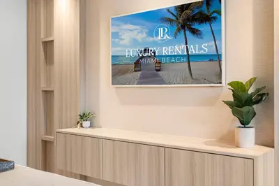a tv screen in a room with a picture of the beach at 2 Bedroom Private Residence at Roney Palace -630 in Miami Beach