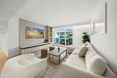 a living room with white furniture and a flat screen tv at 2 Bedroom Private Residence at Roney Palace -630 in Miami Beach